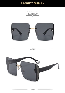Detail of square oversized metal sunglasses with black-gray lenses and golden nose bridge