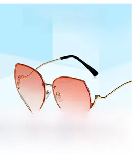Detail of gold metal sunglasses with wavy curved temples and orange gradient lenses