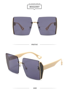 Detail of oversized rimless sunglasses featuring beige temples and grey gradient lenses