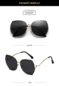 Detail of gold metal cat-eye sunglasses with grey lenses and curved temples