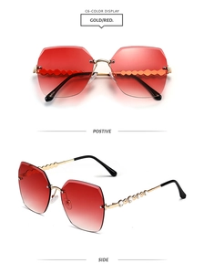 Detail of rimless sunglasses with red gradient lenses and wave-shaped rhinestone temples