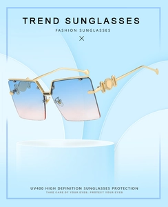 Detail of square rimless sunglasses with blue-pink gradient lenses and gold metal temples
