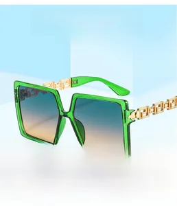 Detail of emerald green square sunglasses with gold Greek key pattern on temples