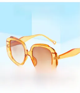 Detail of orange translucent diamond frame sunglasses with brown gradient lenses