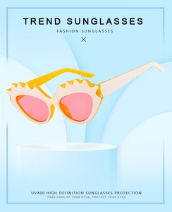 Detail of candy-colored cat-eye sunglasses with scalloped yellow frames and UV400 protection