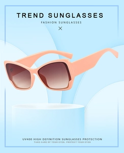 Détail de lunettes de soleil rose pêche avec verres dégradés marron et protection UV400