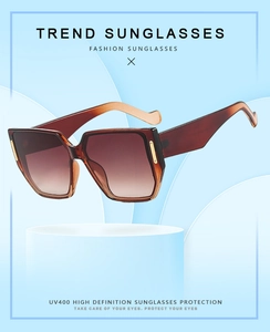 Detail of oversized sunglasses with brown gradient lenses and UV400 protection feature