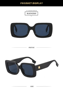 Detail view of black square frame sunglasses with golden square temple accents and grey lenses