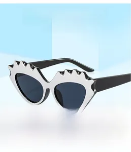 Macro detail of silver heart-shaped sunglasses with wavy metallic edges and dark lenses