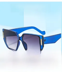 Detail of blue oversized square sunglasses with gradient lenses and gold metal accents
