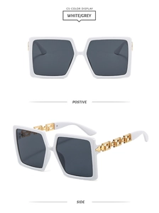 Detail of square white sunglasses with golden hollow Greek pattern on the temples