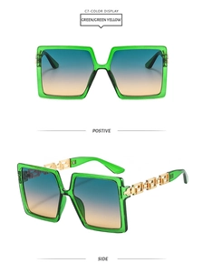 Detail of square oversized sunglasses with green resin frames and gold Greek key temples