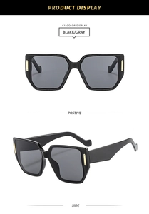 Detail of black irregular oversized square sunglasses with gold metal temple accents