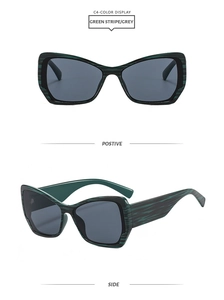 Détail de lunettes de soleil œil de chat avec monture rayée verte et verres gris