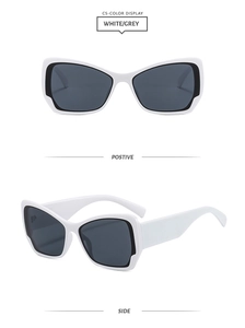 Détail de lunettes de soleil œil-de-chat avec monture blanc-noir et verres gris