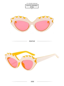 Detail view of cat eye sunglasses with wavy edges and orange pink translucent lenses
