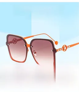 Detail of orange square sunglasses featuring rhinestone-encrusted hollow metal temples