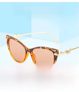 Detail of tortoise cat-eye sunglasses with golden butterfly accents on light blue cubes