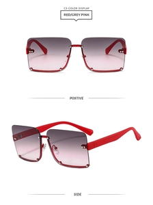 Detail view of square rimless sunglasses with red accents and gradient lenses