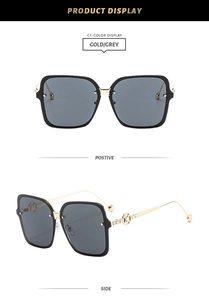Detail of square gold metal sunglasses with crystal-encrusted circular cut-out temples