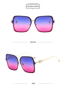 Detail view of gold square sunglasses with diamond-studded temples and blue-pink gradient lenses