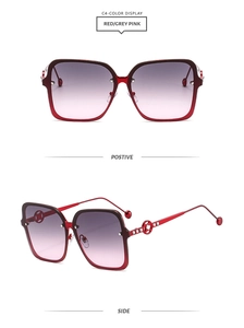 Detail of red square sunglasses featuring diamond-encrusted temples and gradient lenses