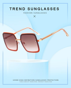 Detail of square red frame sunglasses with gold temples and UV400 gradient lenses