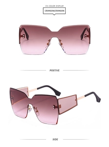 Detail view of oversized rimless sunglasses with crimson gradient lenses and gold temples