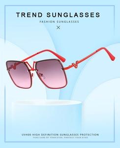 Close-up of sparkling V-shaped rhinestone detail on red oversized metal sunglasses