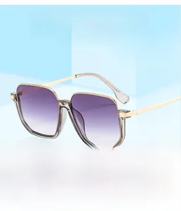 Detail of square oversized sunglasses featuring purple gradient lenses and gold temples