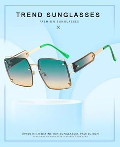 Close-up of square sunglasses with metal rivets and UV400 gradient lenses on a stand
