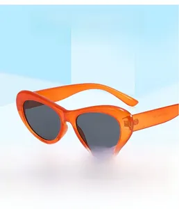 Vue détaillée de lunettes œil de chat orange avec verres foncés sur fond bleu clair
