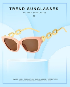 Detail of pink cat-eye sunglasses with gold metal chain arms and UV400 protection lenses