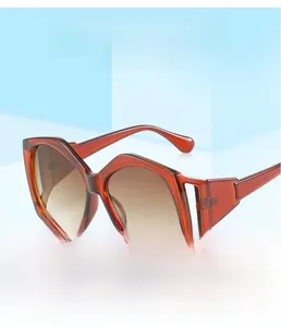 Detail view of oversized irregular red-brown frame sunglasses with hollow temple design