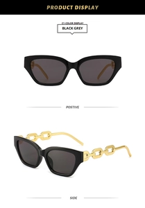 Detail of trendy square sunglasses with bold gold chain temples and grey lenses