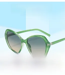 Detail of candy-colored translucent green cat-eye sunglasses with gradient lenses