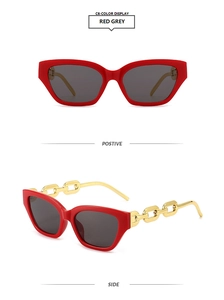 Detail of red cat-eye sunglasses with gold metal chain arms and dark grey resin lenses