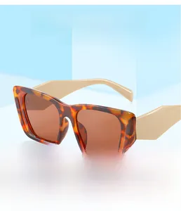 Detail of tortoise shell square sunglasses with bold beige temples and brown lenses