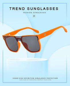 Detail view of orange square sunglasses with UV400 lenses and gold ring temple accents