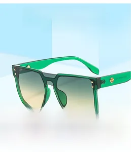 Close-up of translucent green square sunglasses with gradient lenses and metal rivets