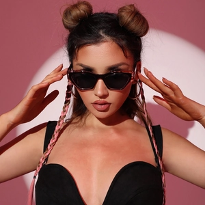 Fashionable two-tone cat-eye sunglasses with dark lenses and pink frames on model