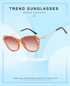 Detail of orange cat-eye sunglasses with UV400 protection on a minimalist display