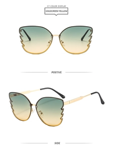 Detail of gold butterfly sunglasses with green-yellow gradient lenses and wing texture