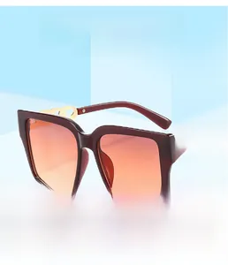 Detail of square sunglasses with burgundy frame, golden chain arms and gradient lenses
