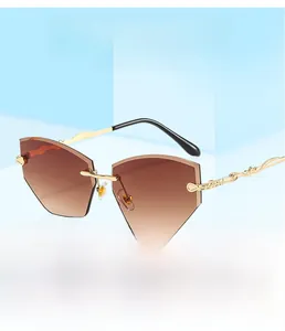 Detail of rimless sunglasses featuring gradient lenses and carved gold metal temples