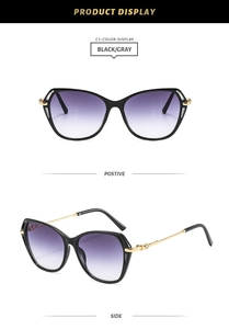 Cat eye sunglasses detail showing black gradient lenses and gold rhinestone metal temples