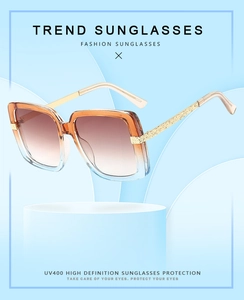 Detail of square sunglasses with champagne frames and textured gold metal temples