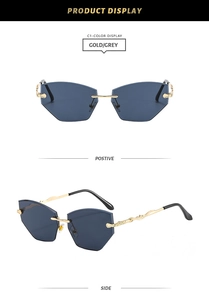 Detail view of rimless geometric sunglasses with gold vine-textured metal temples and grey lenses