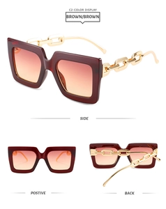Detail view of square tortoise sunglasses with chunky gold chain temples and orange lenses