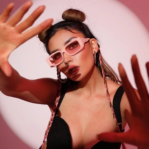 Close-up of pink square frame sunglasses with translucent lenses on fashion model